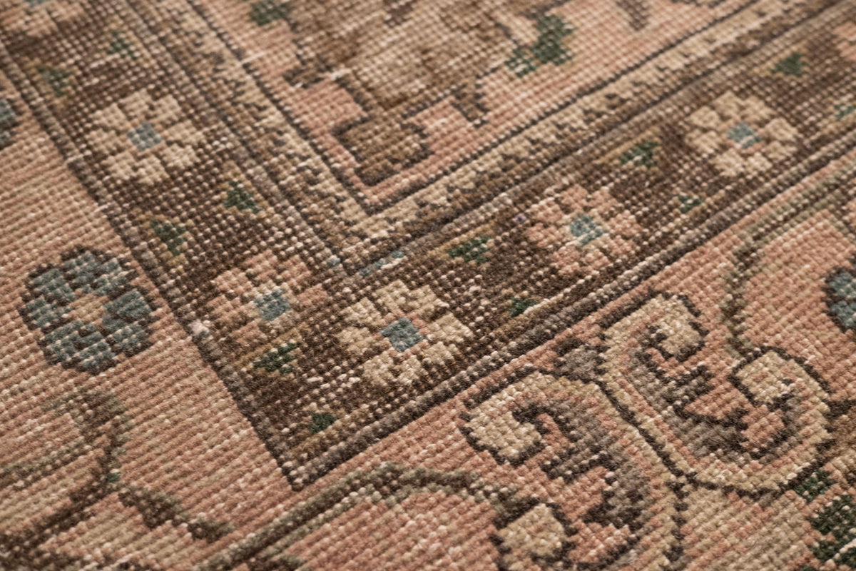 Handmade wool and cotton Persian area rug featuring beige floral patterns and traditional motifs in a low pile texture.