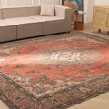 Oversized red Persian-style wool and cotton rug with intricate floral motifs in a traditional bohemian living room.