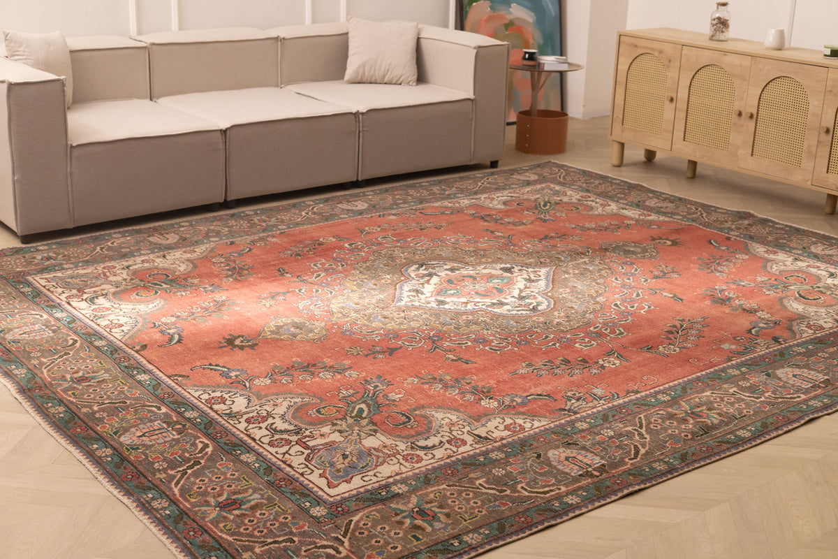 Oversized red Persian-style wool and cotton rug with intricate floral motifs in a traditional bohemian living room.