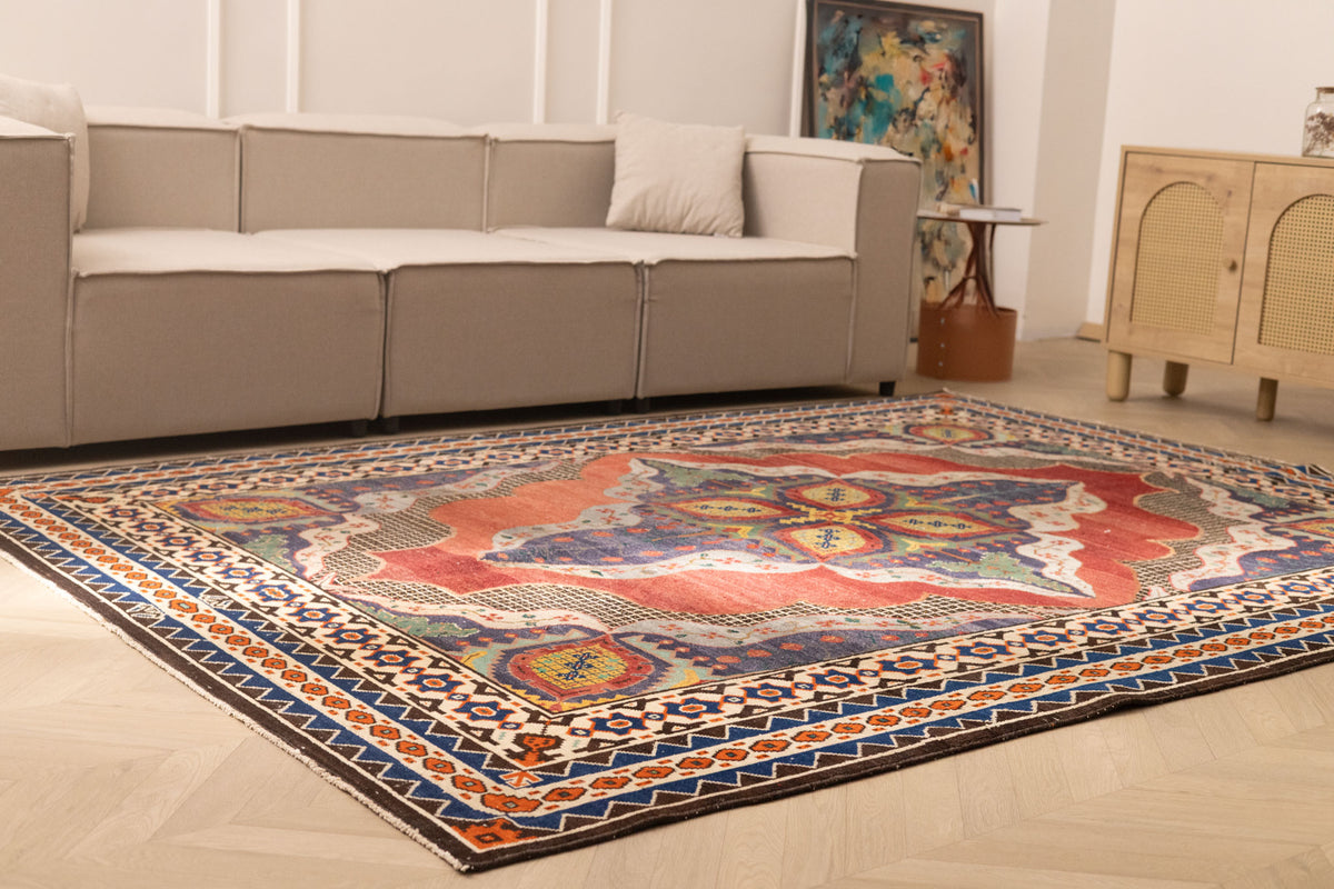 Oversized 7.3 x 10 ft wool and cotton Persian-style area rug featuring a red and navy floral maximalist pattern.