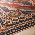 Oversized wool and cotton Persian rug with red and navy floral patterns and a traditional bohemian border.