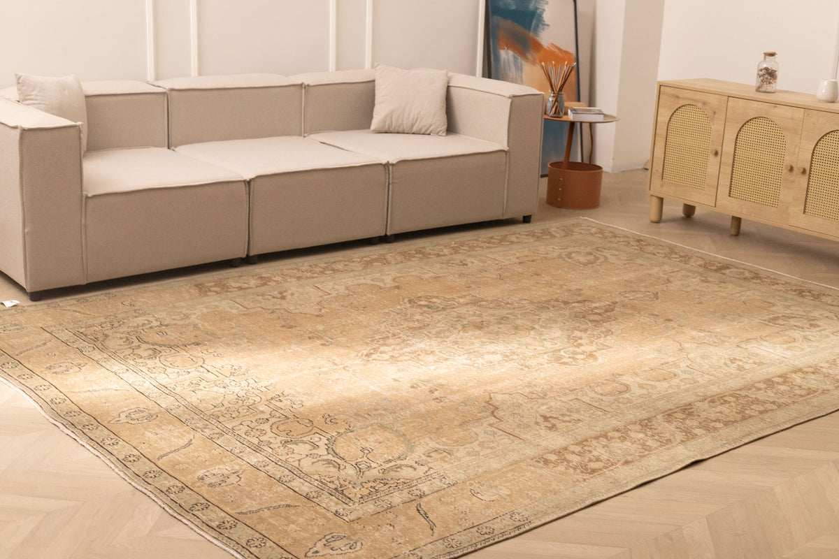 Oversized beige and brown Persian-style wool-cotton rug with traditional floral patterns in a modern living room.