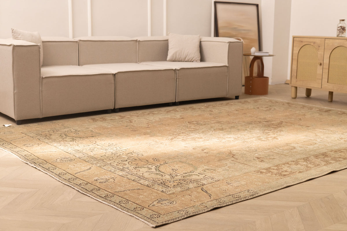 Oversized beige and brown Persian-style wool-cotton rug with traditional floral patterns in a living room.