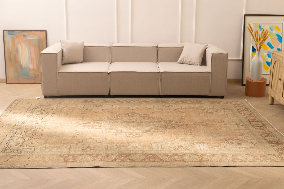 Oversized beige and brown Persian-style wool and cotton area rug with traditional floral patterns in a modern living room.