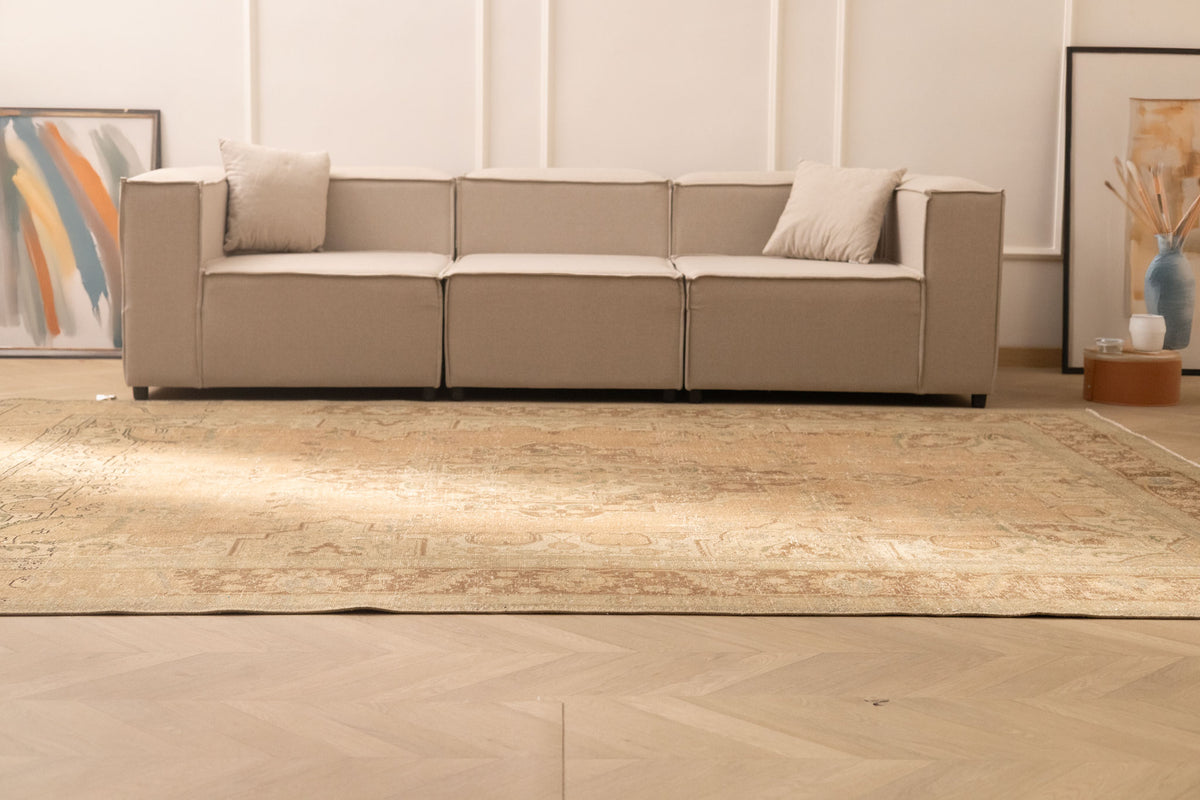 Oversized beige and brown Persian-style wool-cotton rug with traditional floral patterns in a modern living room.