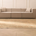 Oversized beige and brown Persian-style wool and cotton rug with traditional floral patterns in a modern living room.