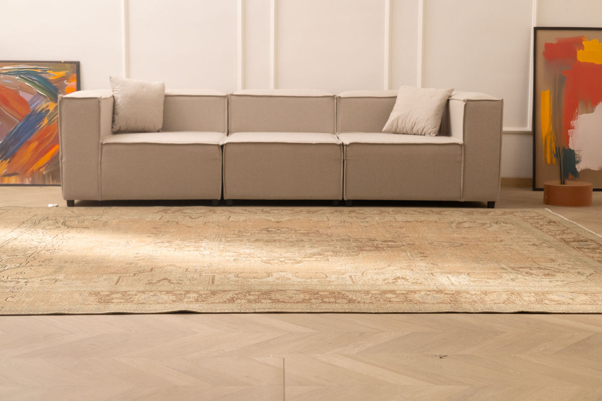 Oversized beige and brown Persian-style wool and cotton rug with traditional floral patterns in a modern living room.