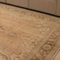 Oversized beige and brown Persian-style wool and cotton rug with traditional floral patterns.