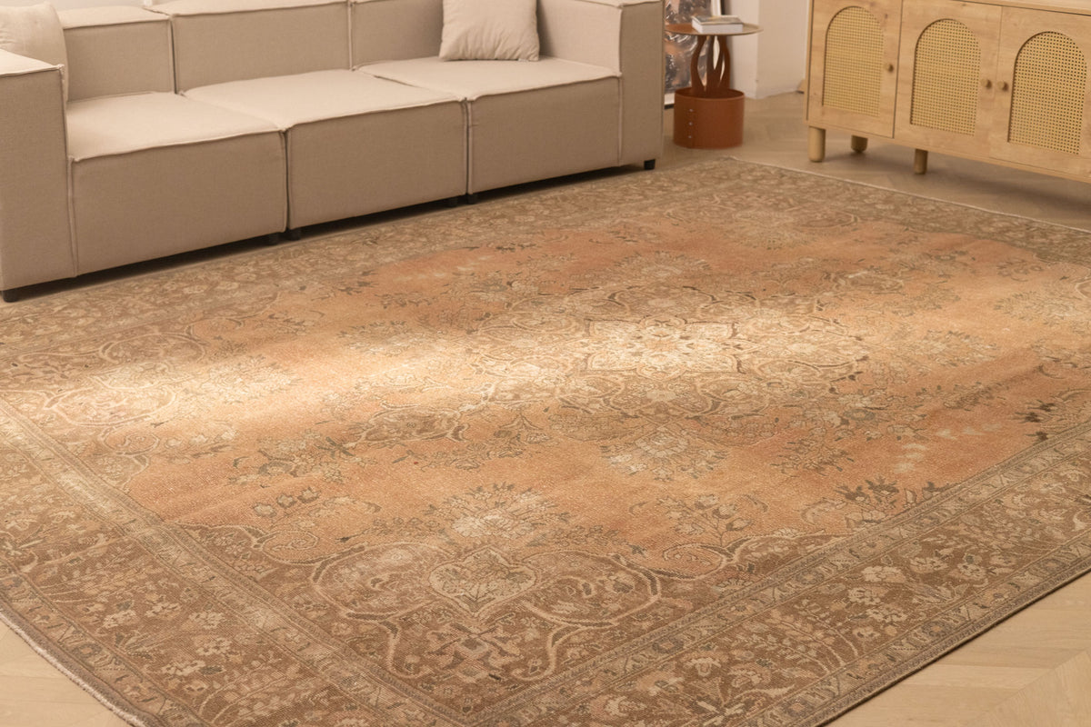 Oversized 9.8x12.8 ft Persian-style wool and cotton rug in orange and brown with traditional floral patterns.