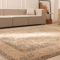 Oversized beige Persian-style wool and cotton rug with intricate geometric and floral patterns in a living room.