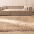 Oversized beige Persian-style wool and cotton rug with intricate geometric and floral patterns in a living room.