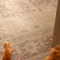 Oversized beige Persian-style wool and cotton rug featuring intricate geometric patterns and floral motifs.