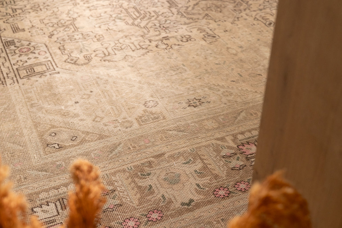 Oversized beige Persian-style wool and cotton rug featuring intricate geometric patterns and floral motifs.