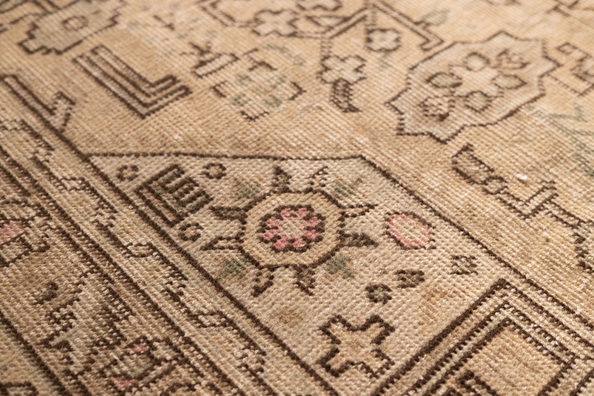 Beige Persian-style wool and cotton rug with intricate geometric floral motifs and a low-pile traditional design.