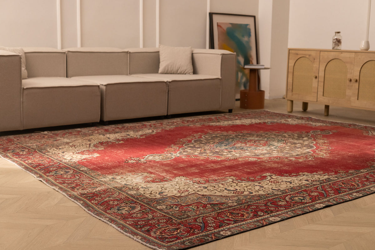 Oversized red Persian-style wool and cotton area rug with intricate floral patterns in a modern living room.
