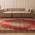 Oversized red Persian-style wool and cotton area rug featuring traditional floral motifs in a living room setting.