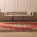 Oversized red Persian-style wool and cotton area rug with intricate floral patterns in a modern living room.