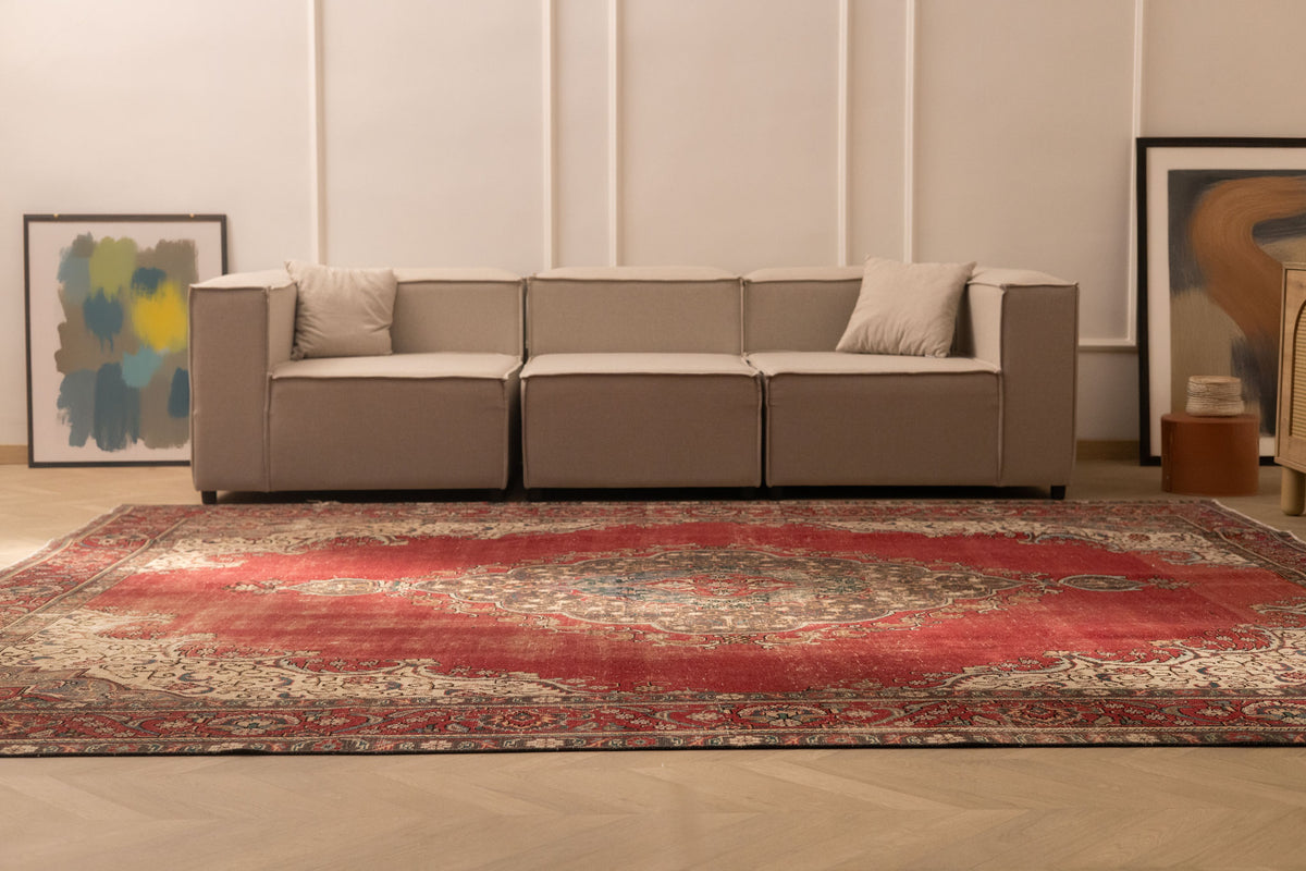 Oversized red Persian-style wool and cotton area rug with intricate floral patterns in a modern living room.
