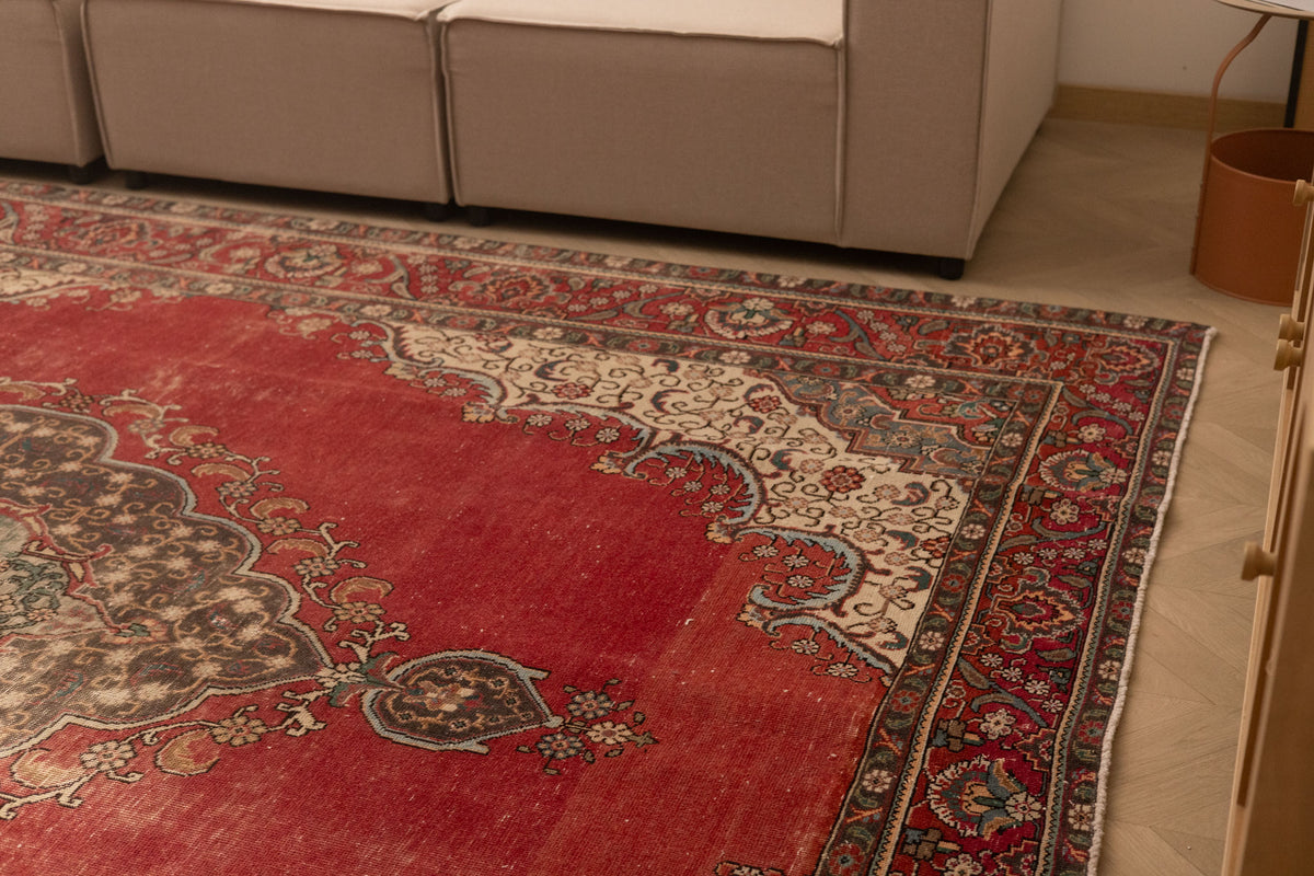 Oversized red Persian-style wool and cotton area rug featuring intricate floral motifs and traditional bohemian patterns.