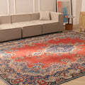 Oversized red and navy Persian-style wool and cotton area rug featuring intricate floral patterns in a living room.