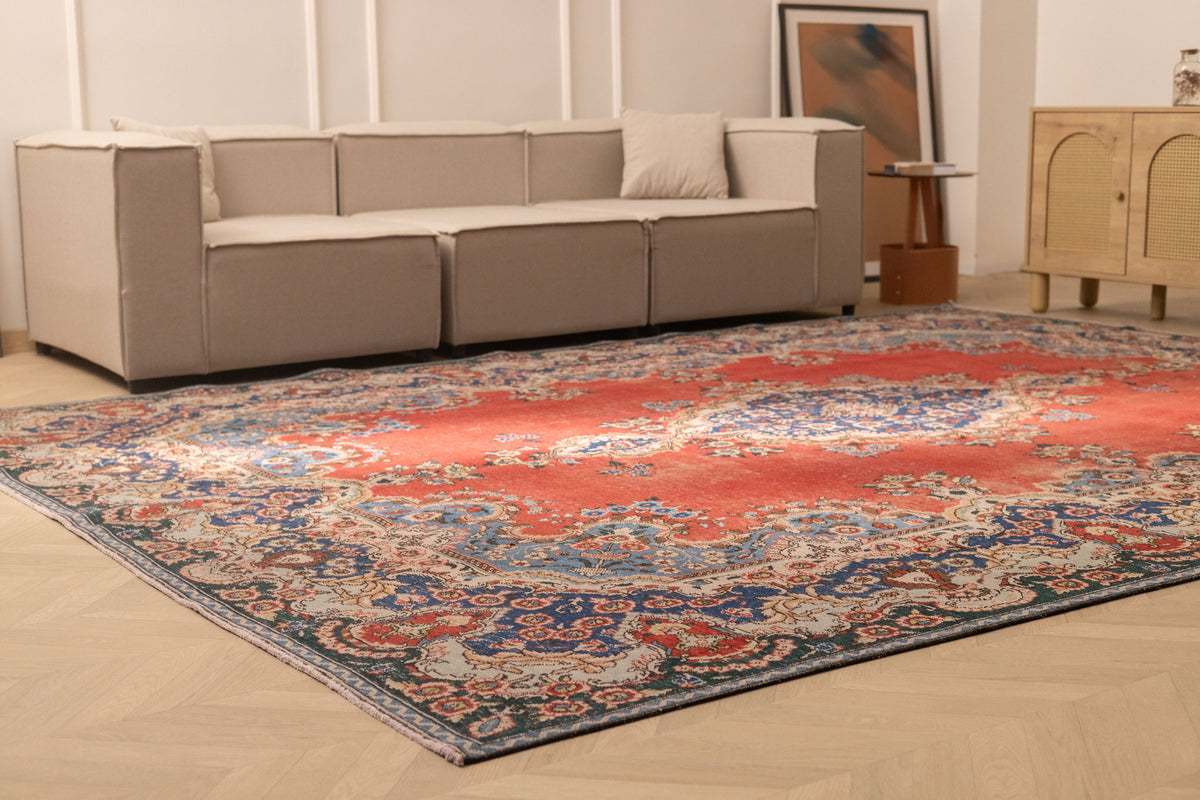 Oversized 9.7x12.6 ft Persian-style wool and cotton area rug featuring traditional red and navy floral patterns.