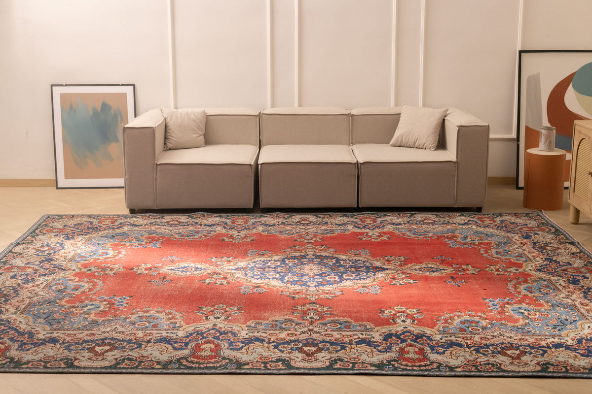 Oversized red and navy Persian-style wool and cotton area rug with intricate floral patterns in a modern living room.