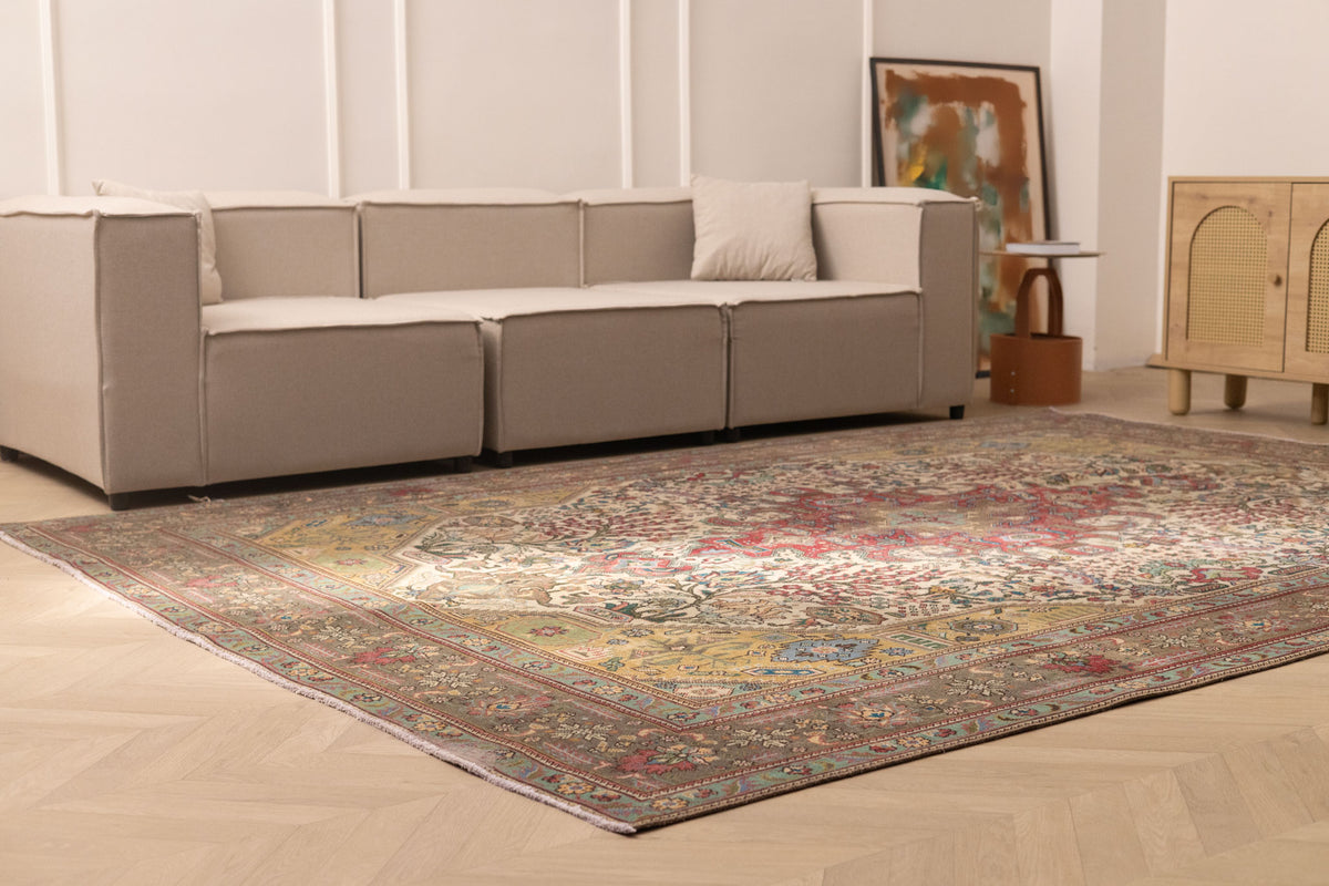 Oversized Persian-style wool and cotton area rug featuring red and floral patterns in a bohemian living room.