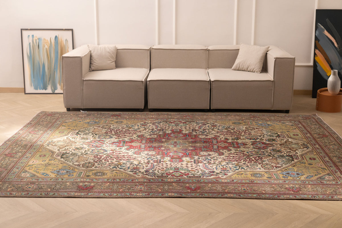 Oversized Persian-style wool and cotton rug featuring intricate red and floral patterns in a traditional bohemian design.