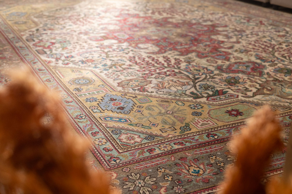 Oversized wool and cotton Persian-style area rug featuring intricate red and floral patterns in a traditional bohemian design.