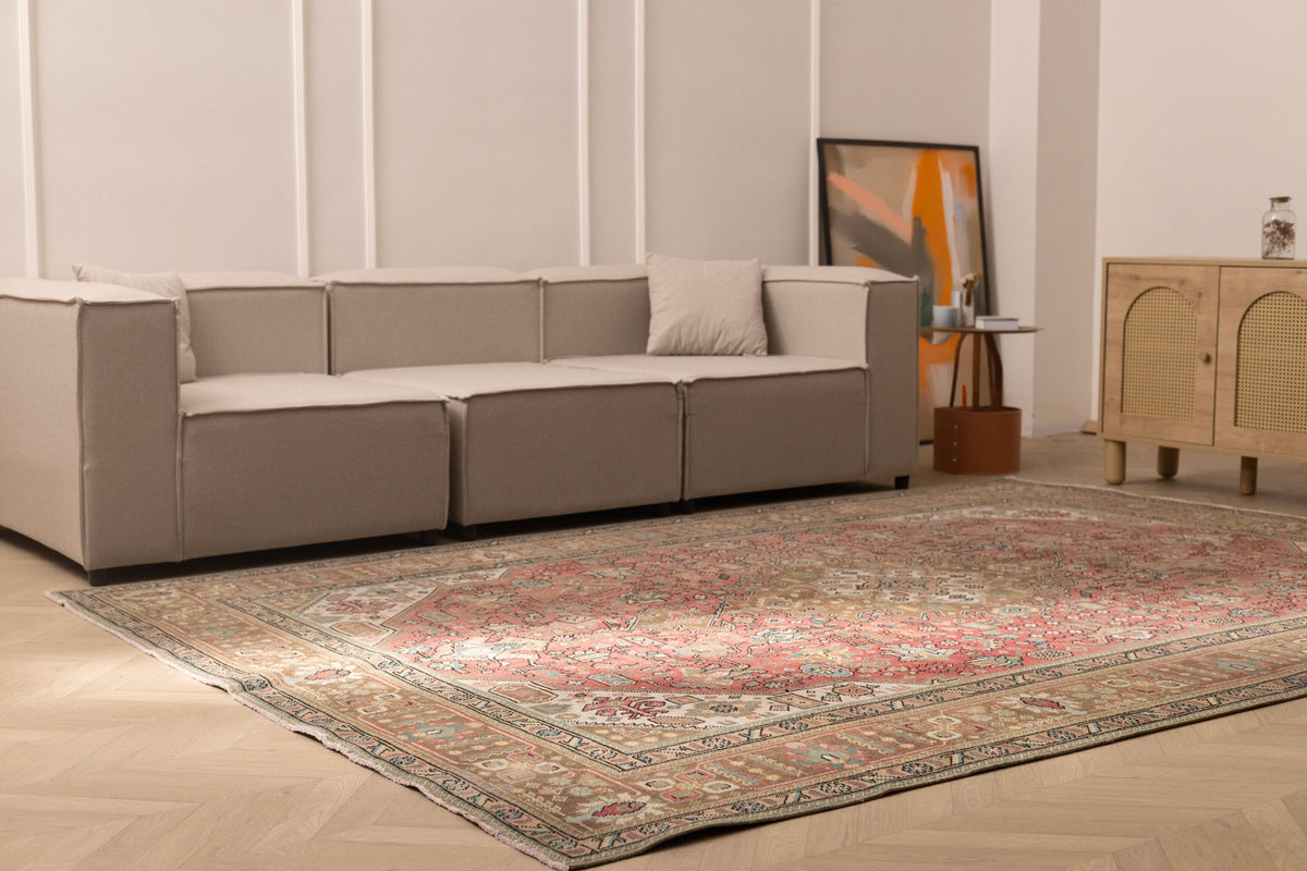 Oversized Persian-style wool and cotton area rug with red and brown floral patterns in a modern living room.