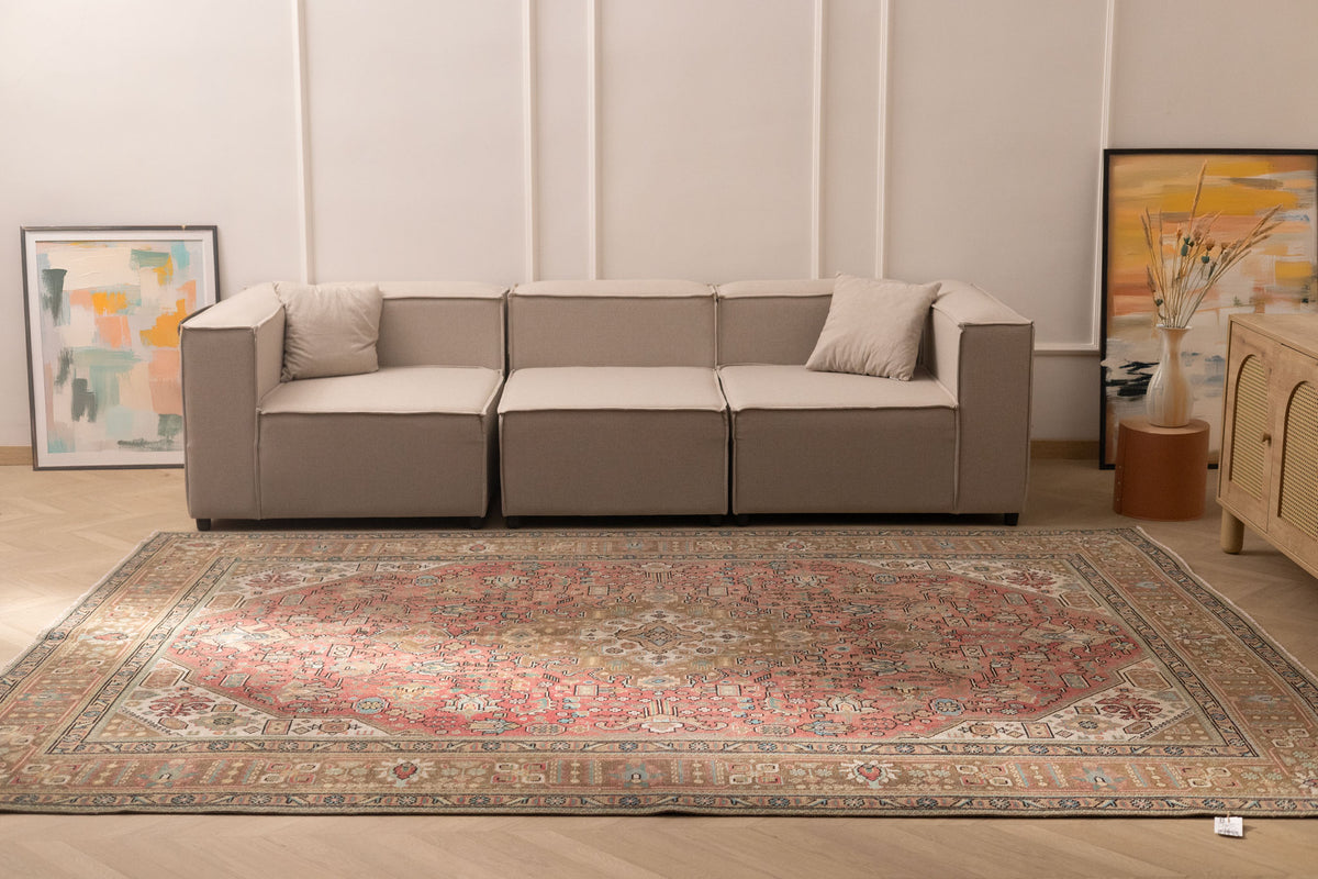 Oversized Persian-style wool and cotton area rug with red and brown floral patterns in a bohemian living room.