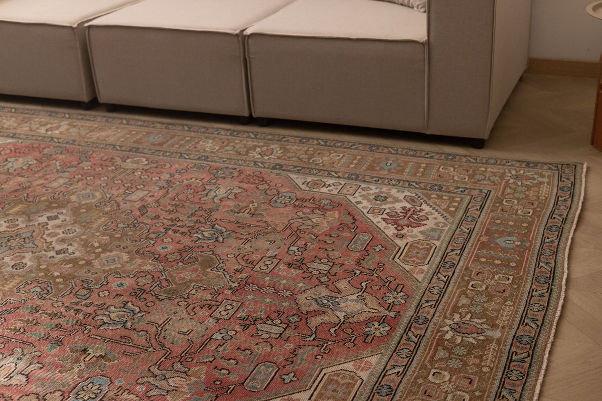 Oversized 7.7x11 ft Persian-style wool and cotton rug in red and brown with traditional floral motifs.