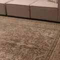 Oversized 7.9x11 ft Persian-style wool and cotton rug in beige and brown with traditional floral patterns.