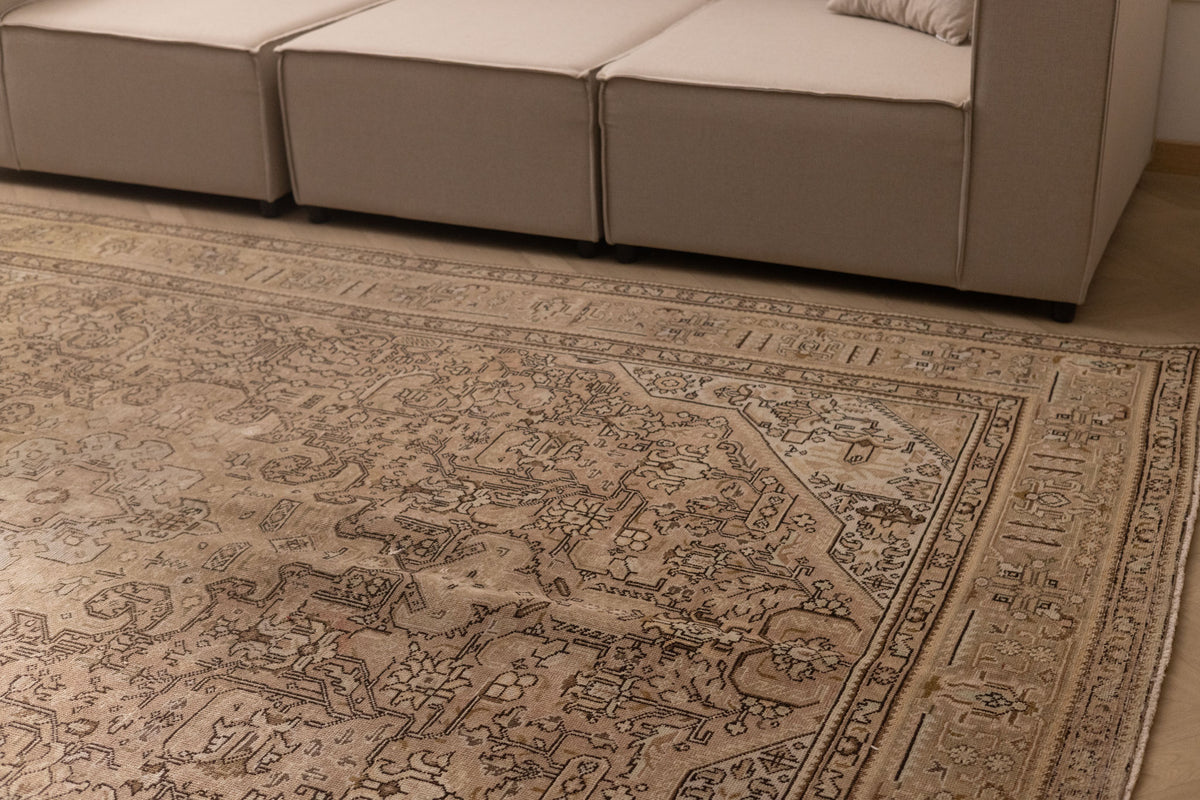 Oversized 7.9x11 ft Persian-style wool and cotton rug in beige and brown with traditional floral patterns.