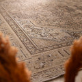 Oversized 7.9x11 ft wool and cotton Persian-style rug in beige and brown with intricate floral and traditional patterns.