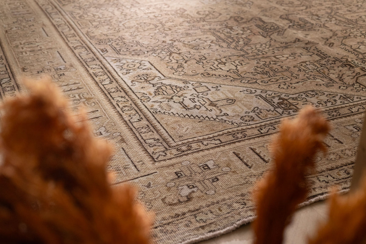Oversized 7.9x11 ft wool and cotton Persian-style rug in beige and brown with intricate floral and traditional patterns.