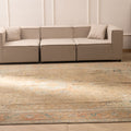 Oversized Persian-style wool and cotton rug in brown and orange with intricate floral patterns in a living room.