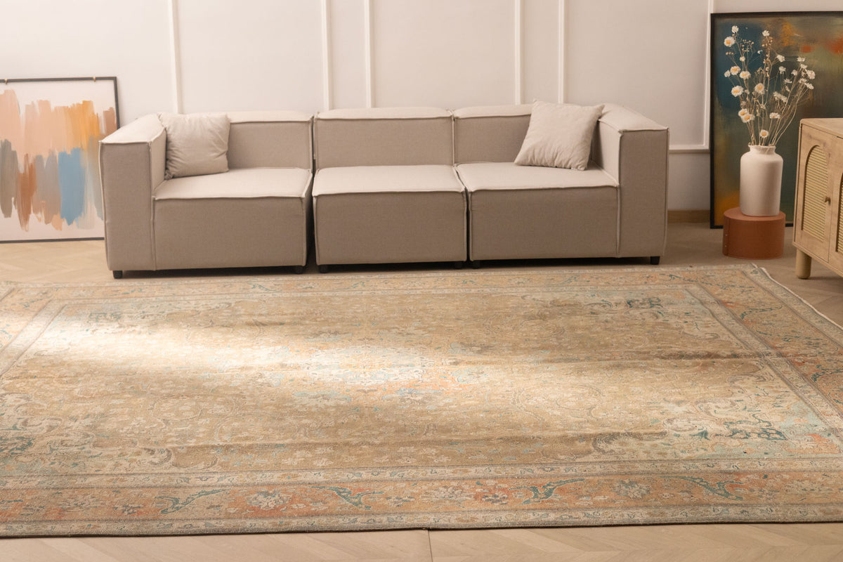 Oversized Persian-style wool and cotton rug in brown and orange with intricate floral patterns in a living room.