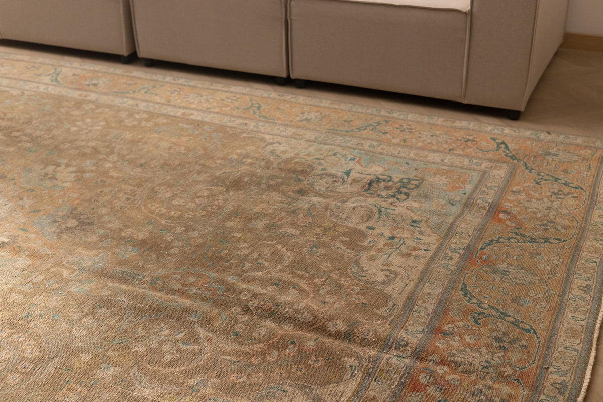 Oversized wool and cotton Persian-style rug in brown and orange with floral motifs and maximalist patterns.