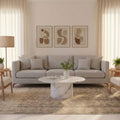 Oversized beige Persian-style wool and cotton area rug with intricate traditional floral motifs in a bright living room.
