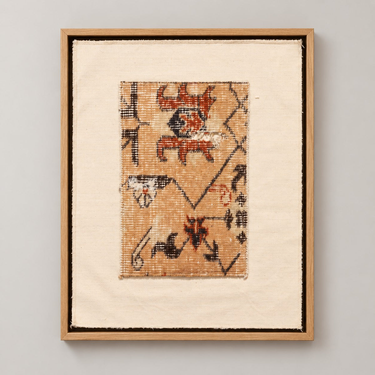 Framed vintage rug fragment wall art in apricot, rust, navy, black