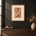 Framed vintage rug fragment wall art in apricot, rust, navy, black hanging on a dark wall above a wooden console