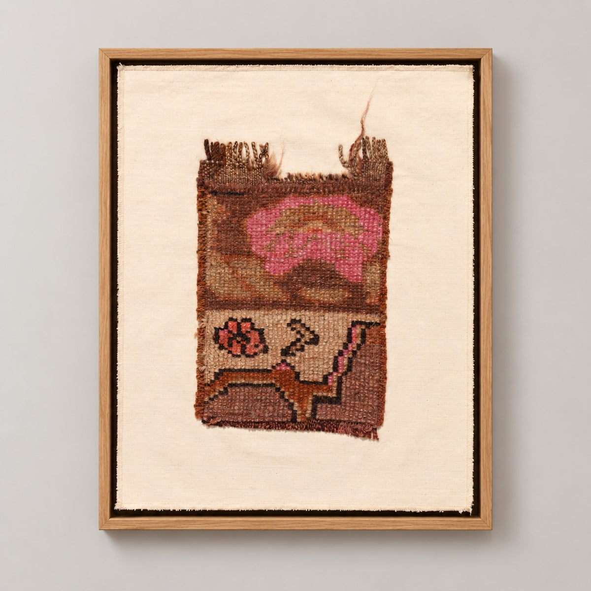 Framed vintage rug fragment wall art in brown, pink, cream