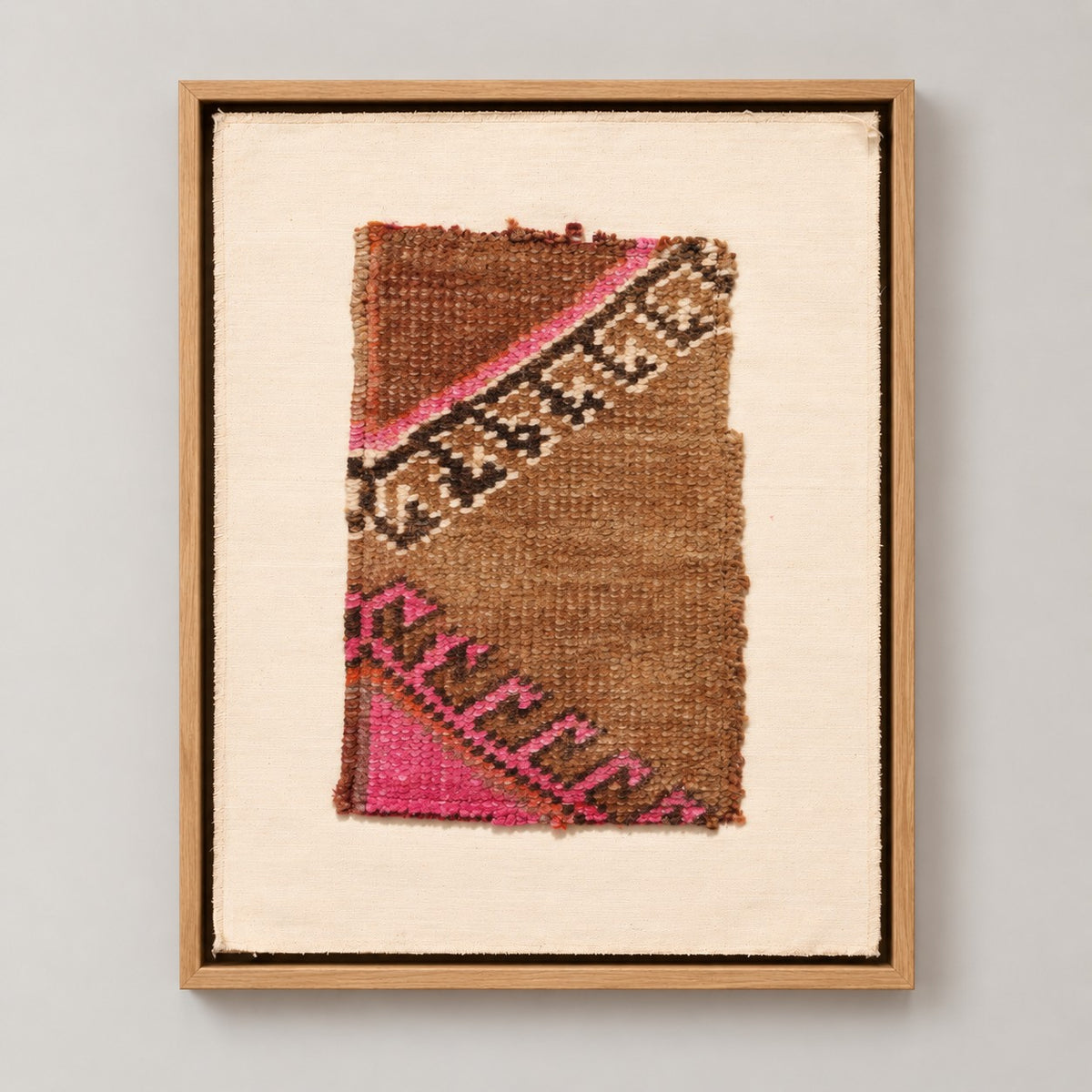 Framed vintage rug fragment wall art in camel, pink, black